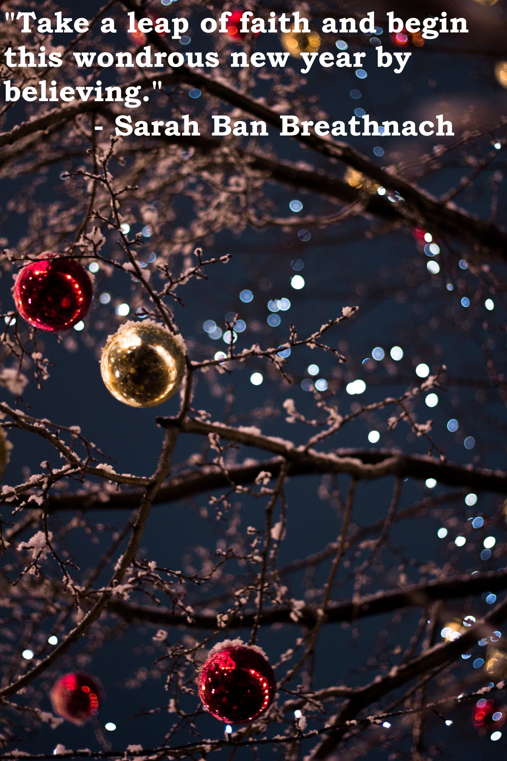 Festive tree branches with snow and glowing baubles against night sky, New Year quote by Sarah Ban Breathnach.