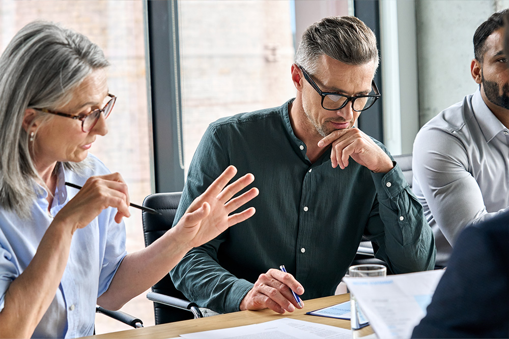 Team of professionals engaged in a focused discussion during a business meeting, showcasing collaboration and strategic planning.