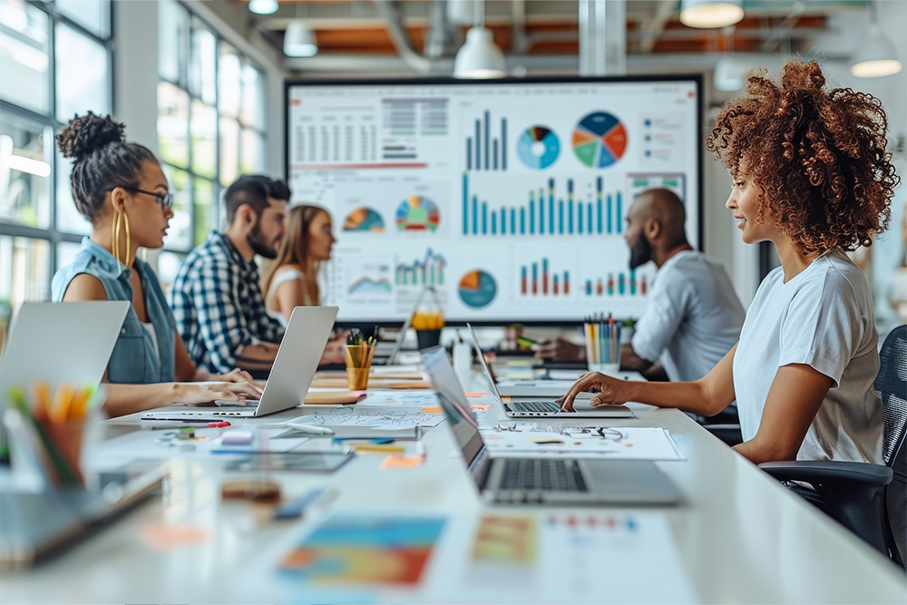 Team analyzing data charts on a large screen in a modern office, highlighting collaboration, analytics, and data-driven decision-making.